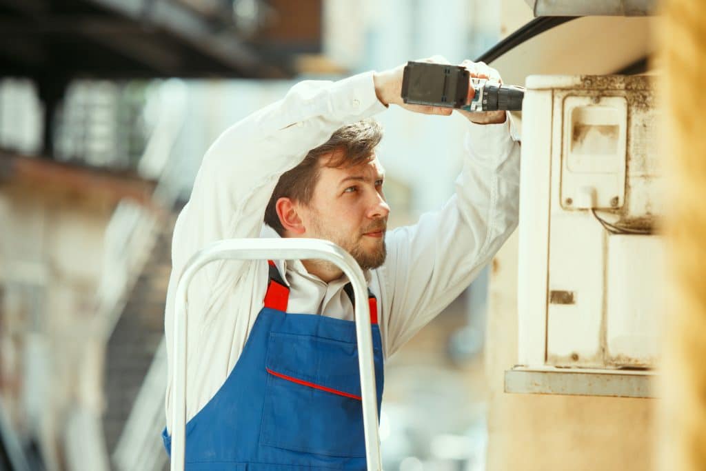 hvac technician working capacitor part condensing unit 1024x683 1
